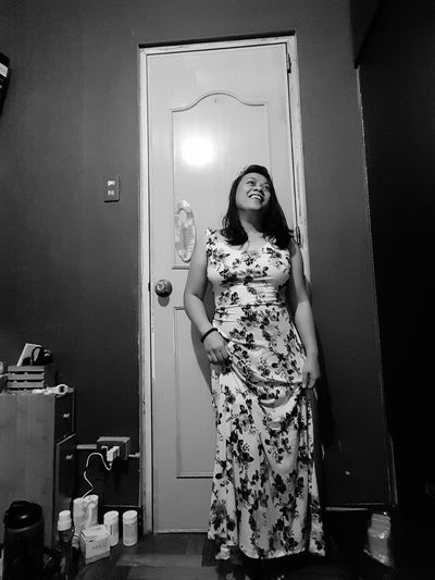 Portrait of woman standing against door at home