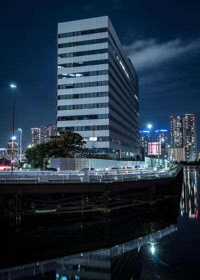 Modern buildings against sky in city at night
