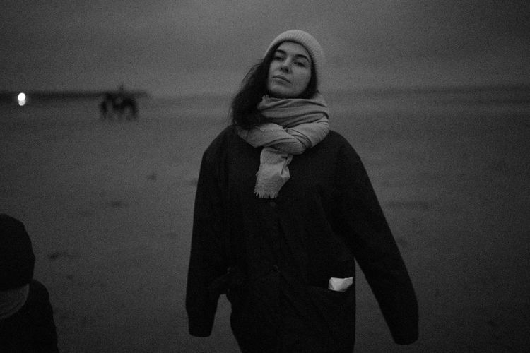 Portrait of woman standing at beach during winter