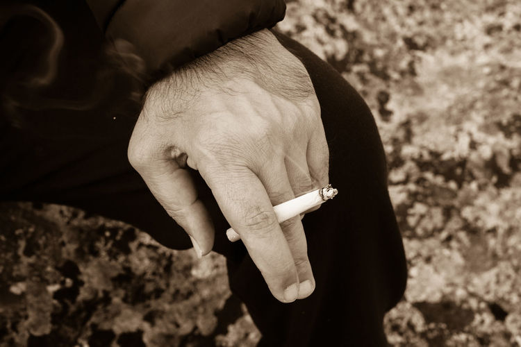Close-up of man holding cigarette