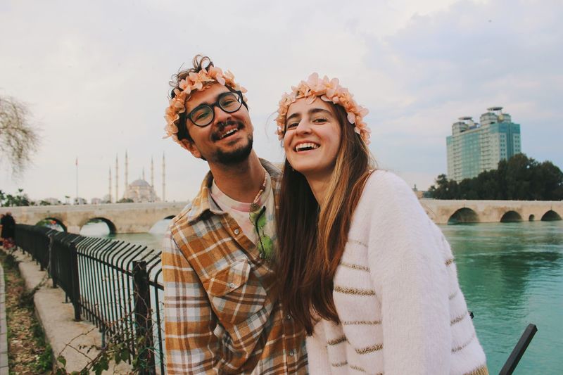 Portrait of happy young couple smiling behind old stone bridge of adana turkey