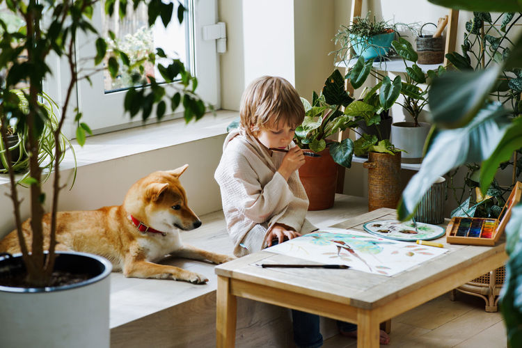 Portrait of young woman with dog at home