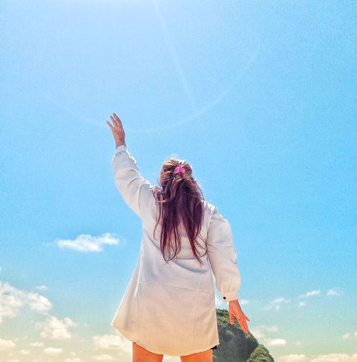 Rear view of woman standing against sky