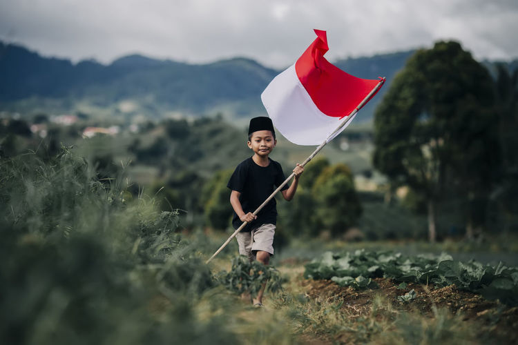 Kid running holding indonesian flag