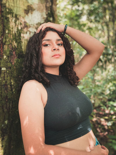 Portrait of woman standing against tree