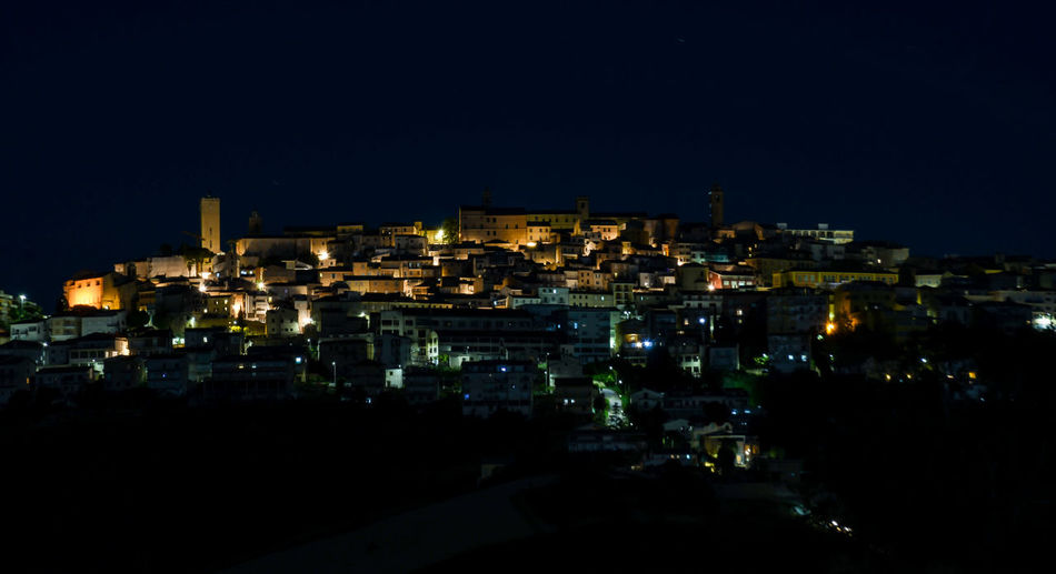 High angle view of illuminated buildings against clear sky at night