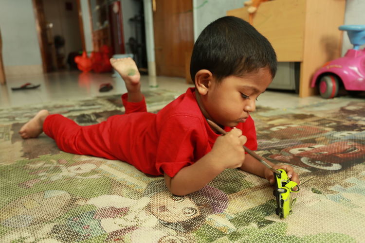 Portrait of child playing with toy car