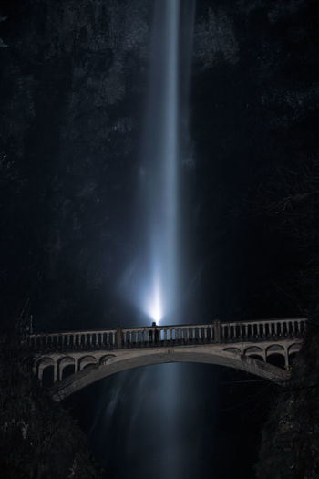 Low angle view of bridge against waterfall at night