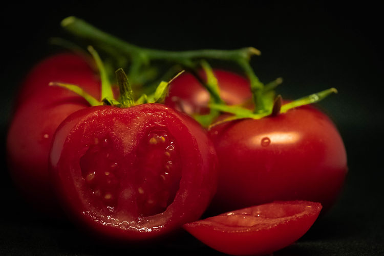 Close-up of red berries on table against black background