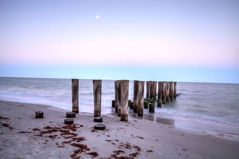 Dilapidated pier leading into the ocean on the beach of port royal in naples, florida 