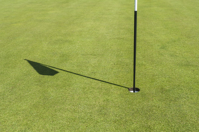 Shadow of golf flag on course