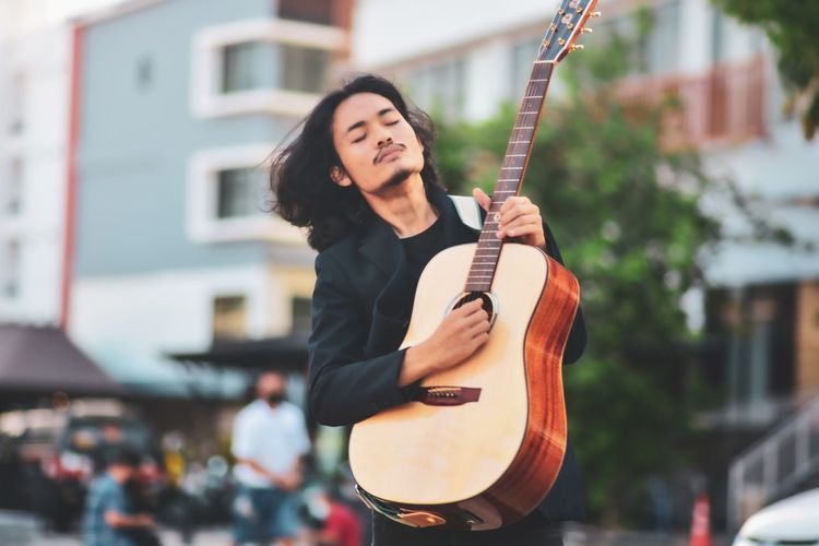 Man playing guitar on the street. retro style.