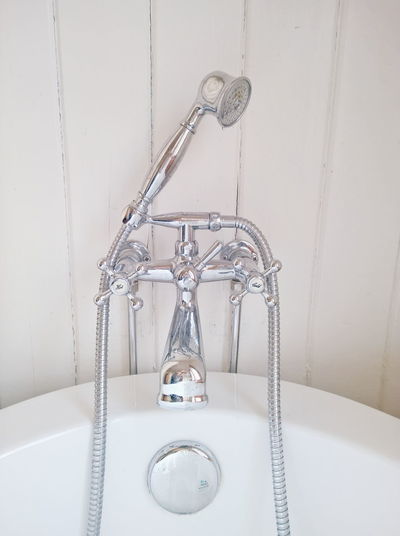 Shower head connected to faucet on bathtub