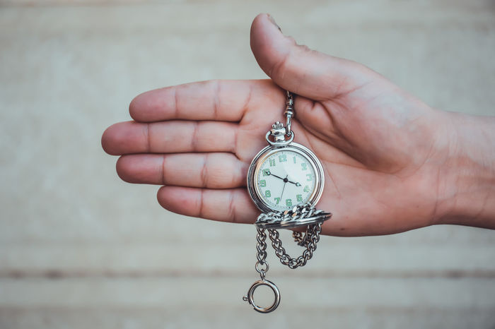 Close-up of hand holding pocket watch
