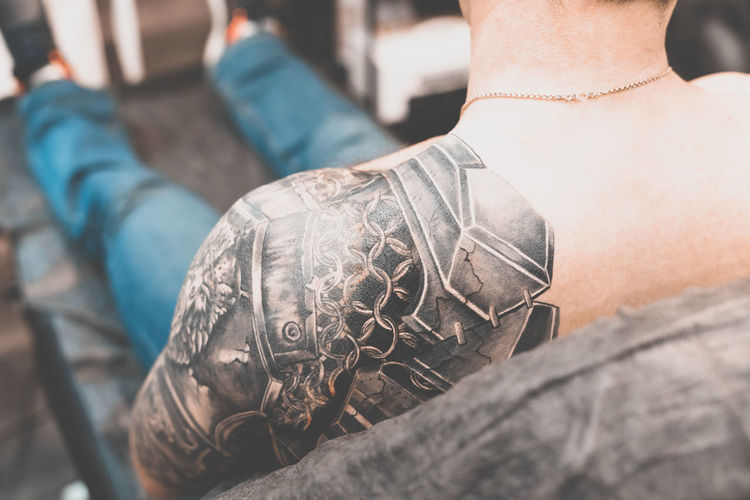 Midsection of man getting tattoo