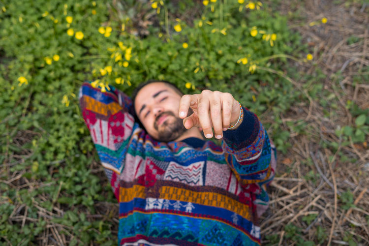 Moroccan man laying on the ground and holding his hand up to the camera