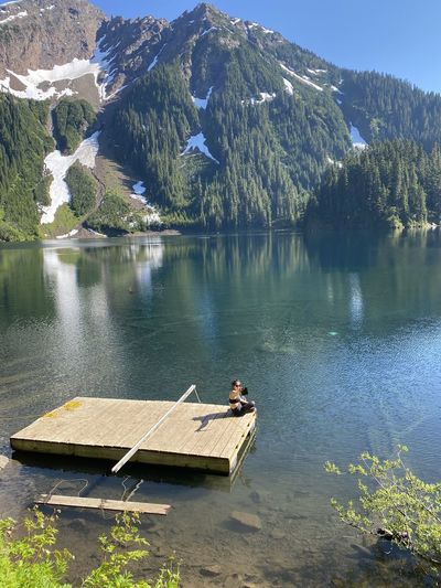 High angle view of woman doing selfie while sitting by lake