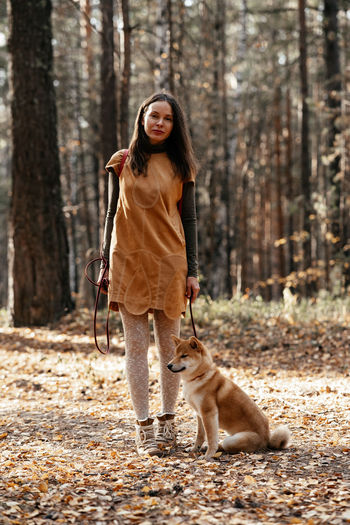 Woman with dog walking in forest