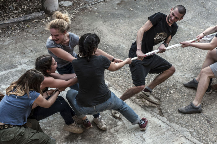 High angle view of friends playing tug-of-war on street