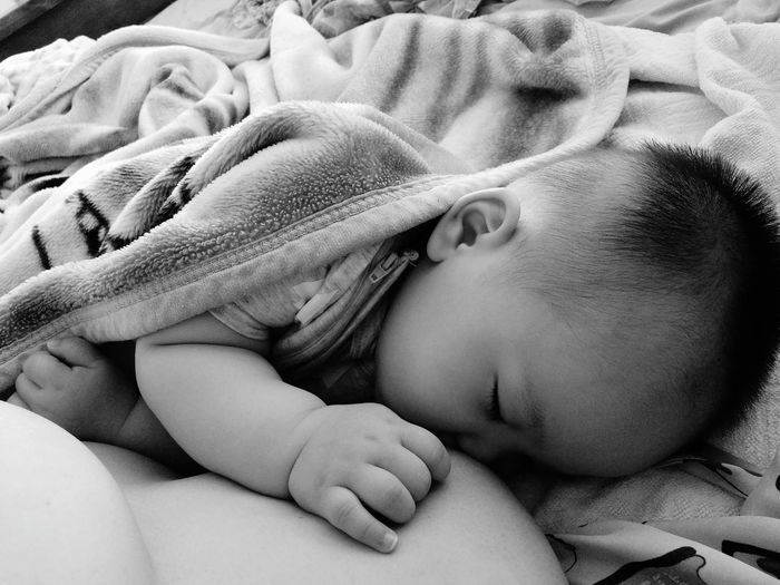 Cropped image of woman breastfeeding baby