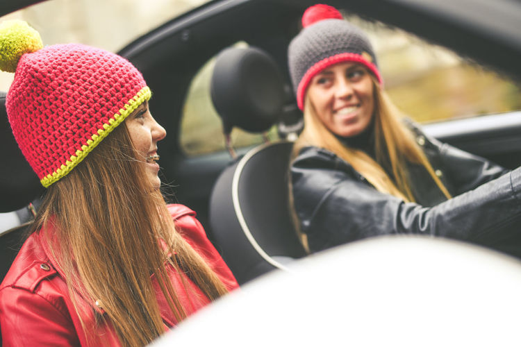 Girls sitting in the car. smiling teen in front of the steering wheel young women enjoying free time