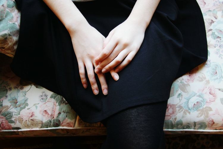 High angle view of hands of a young woman on lap