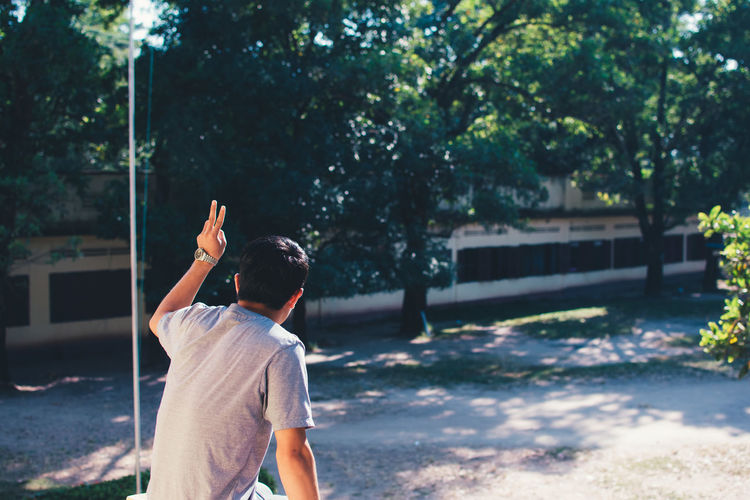 Man gesturing peace sign on street