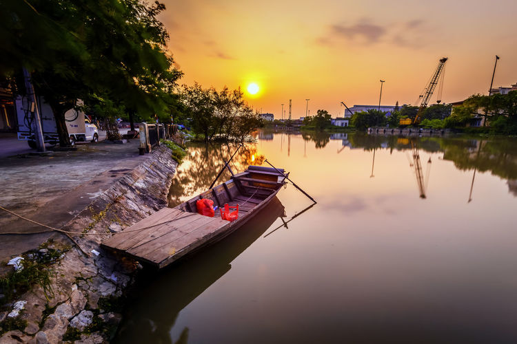 High angle view of boat moored at river against sky during sunset