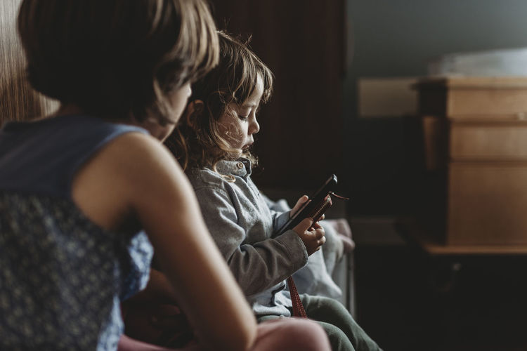 Side view of young boy playing on phone in hospital
