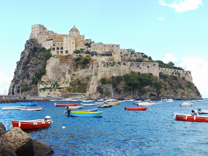 Low angle view of aragonese castle in front of sea against sky
