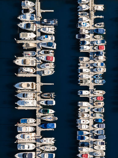 Aerial view of sailboats moored in sea against buildings in city