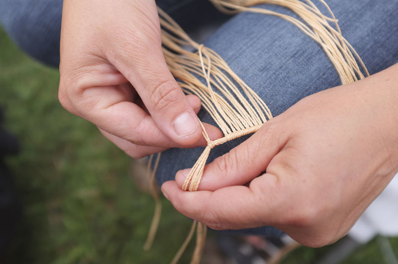 Close-up of hands tying strings