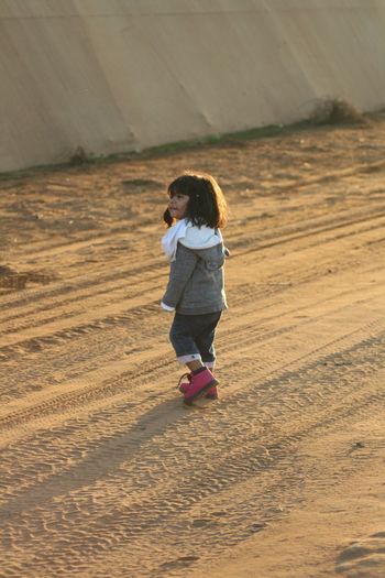 Smiling girl walking on dirt road