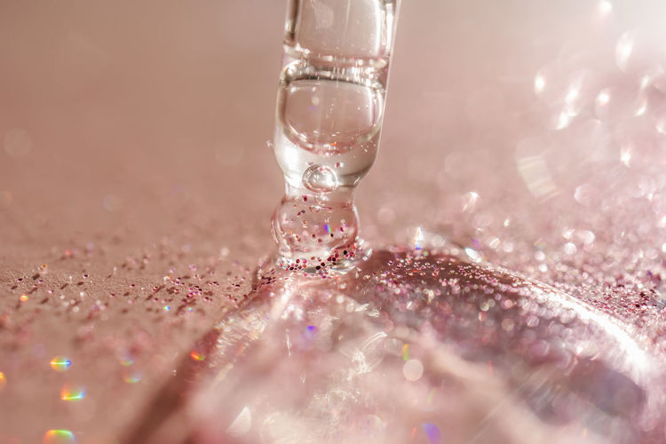 The texture of the serum or oil on an emerald background.