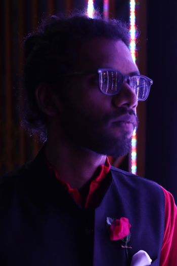 Young man wearing eyeglasses looking away at night