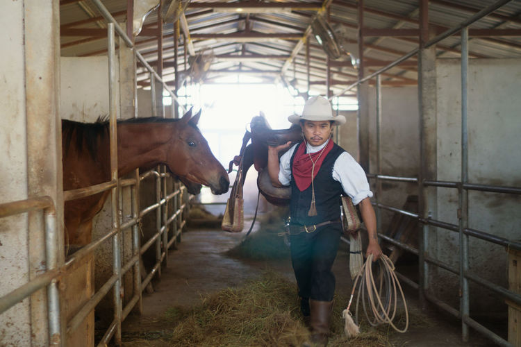 Cowboy walking in barn