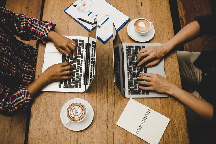 Two businessmen working together by using laptop