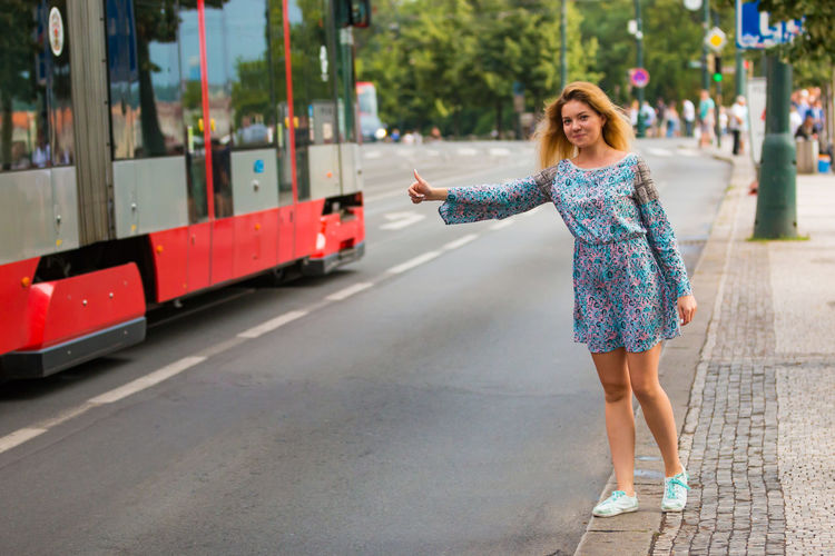 Woman hitchhiking on street