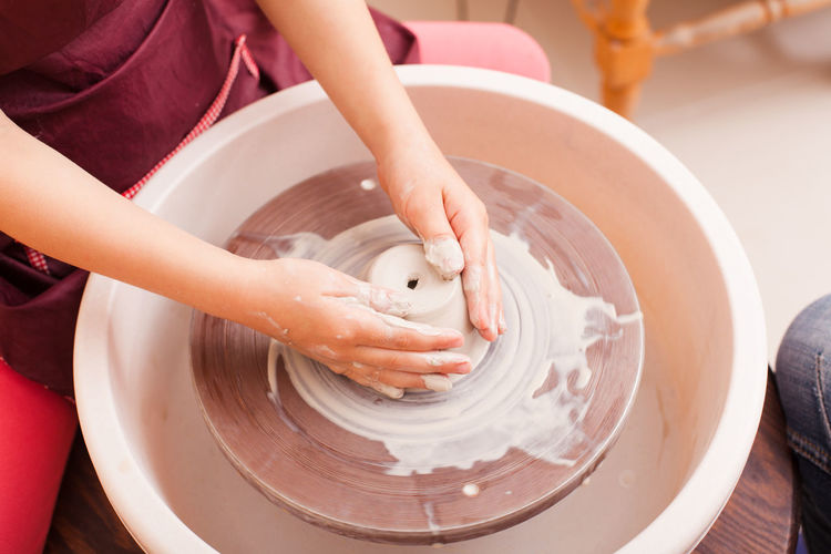 Midsection of girl making pottery
