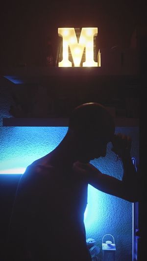Portrait of man on illuminated window at home