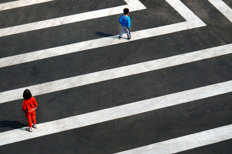Rear view of man walking on zebra crossing