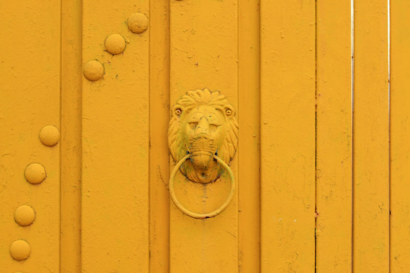 Close-up of knocker on yellow door