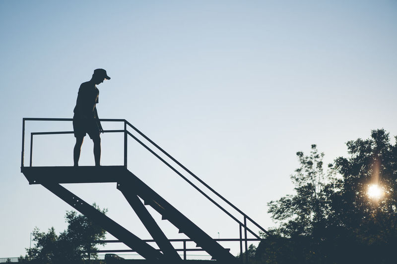 Low angle view of man on steps against clear sky