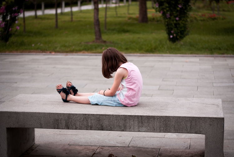 Little girl sitting alone on the bench