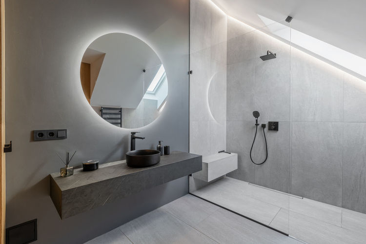 Beautiful elegant modern luxury bathroom interior in luxury home and glass door shower, mirror sink