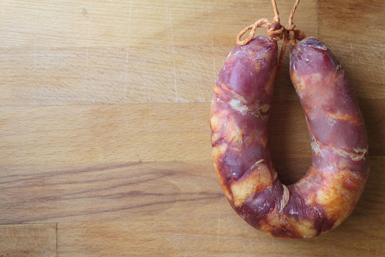Traditional portuguese sausage chorizo on wooden board. top view with copy space