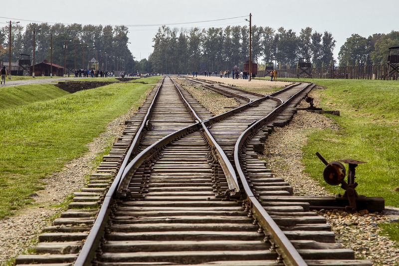 Rear view of man walking on railroad track