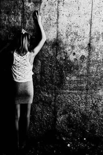 Rear view full length of girl standing against old wall
