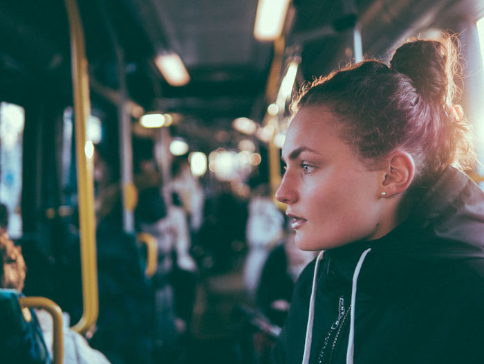 Side view of beautiful woman with hair bun in bus