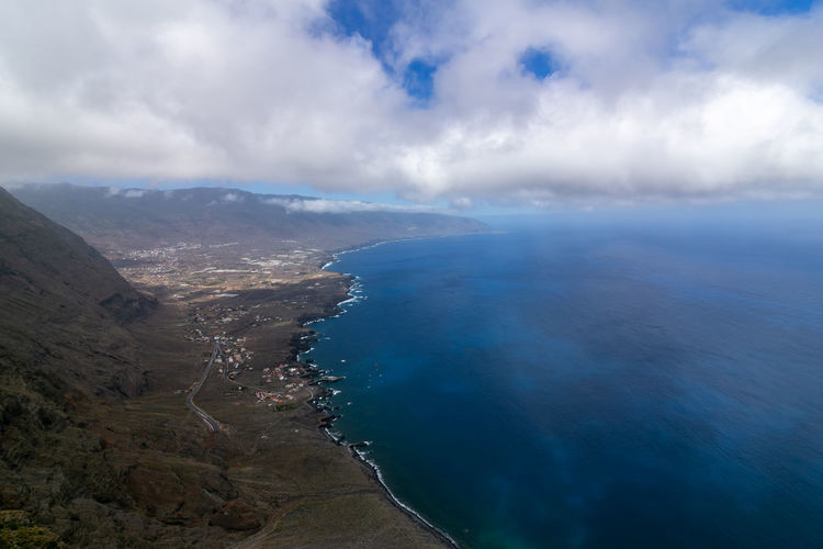 Aerial view of sea and mountains against sky
